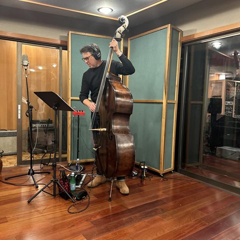 Sean Hurley standing with his upright bass in the studio live room.