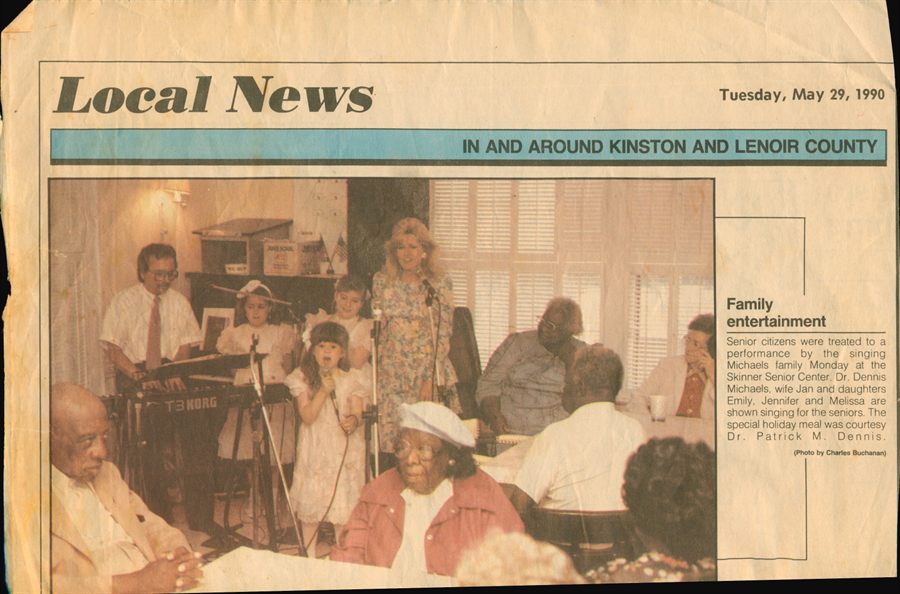 A yellowed Local News clipping from Kinston, North Carolina, dated Tuesday 29 May 1990, showing the family singing for residents at the Skinner Senior Center under the headline Family entertainment.
