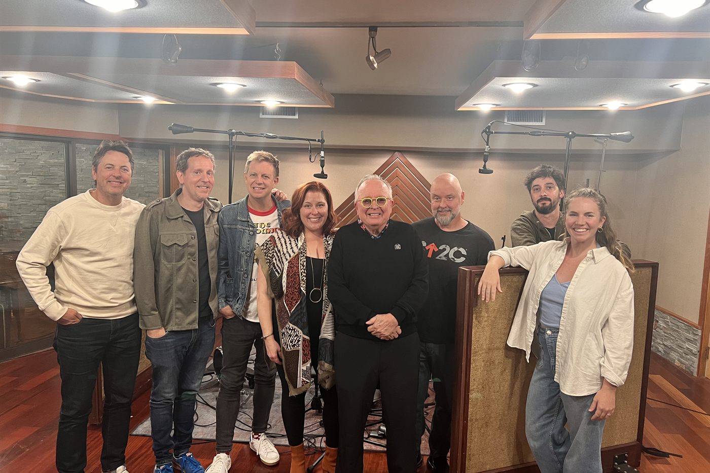 Eight people standing together in the LMNL live room at the end of the sessions, smiling at the camera.